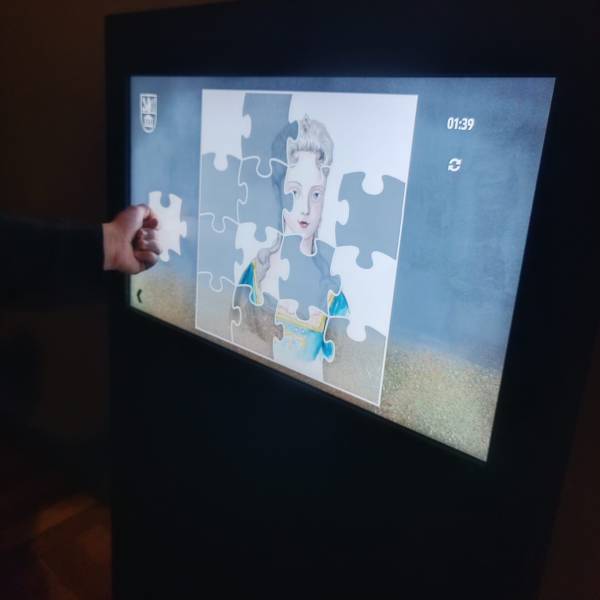 Hra puzzle na displeji s interaktivní databází.
